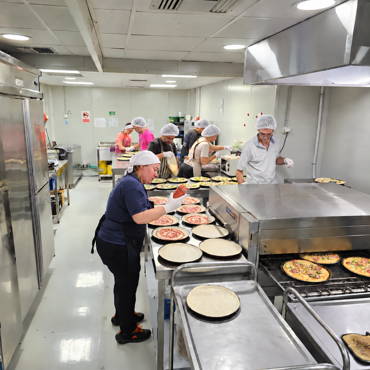 Η ομάδα της COOK@MAITRE προετοιμάζει πίτσες στην κουζίνα